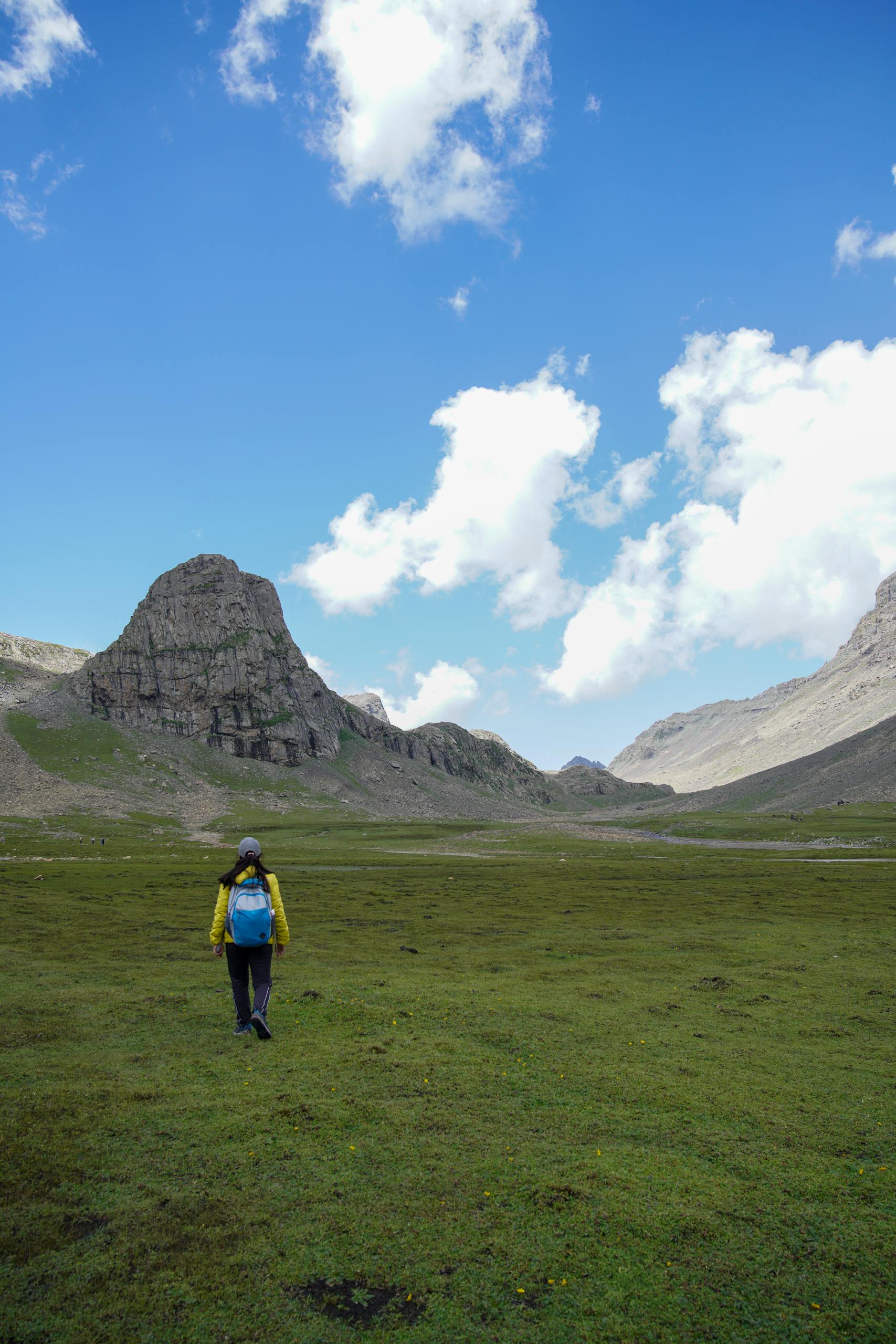 Explore the breathtaking landscapes of Shallabugh with a solo hiker under a vibrant blue sky.